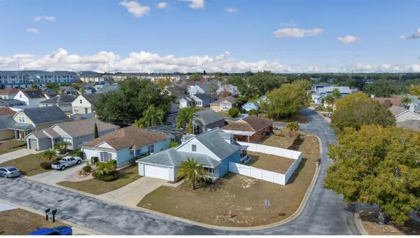 an aerial view of a house with yard swimming pool and mountain view in back