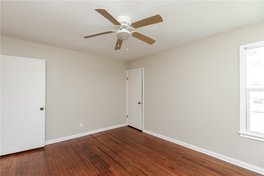 3513 Monterrey Street Corpus Christi, TX 78411 - Photo 12 of 34 an empty room with wooden floor ceiling fan and windows
