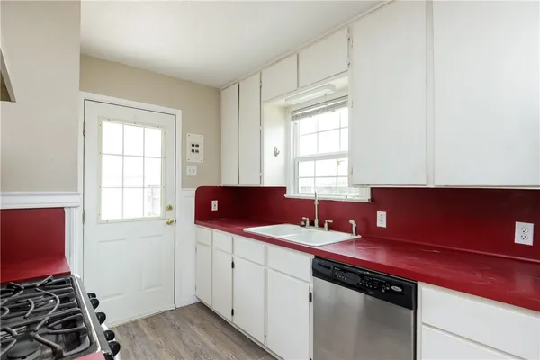 a kitchen with a sink stove top oven and cabinets