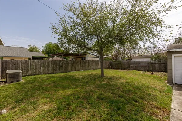 a view of a backyard with table and chairs and wooden fence