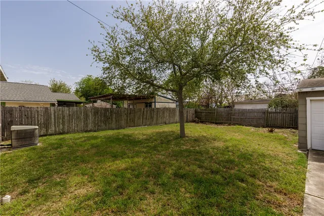 a view of a backyard with table and chairs and wooden fence