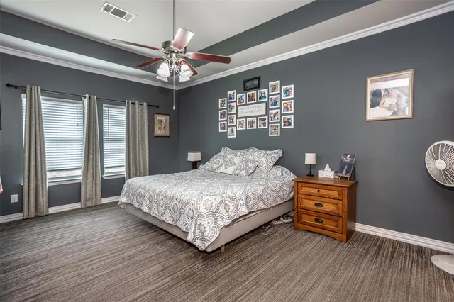 a spacious bedroom with a bed chandelier and a window