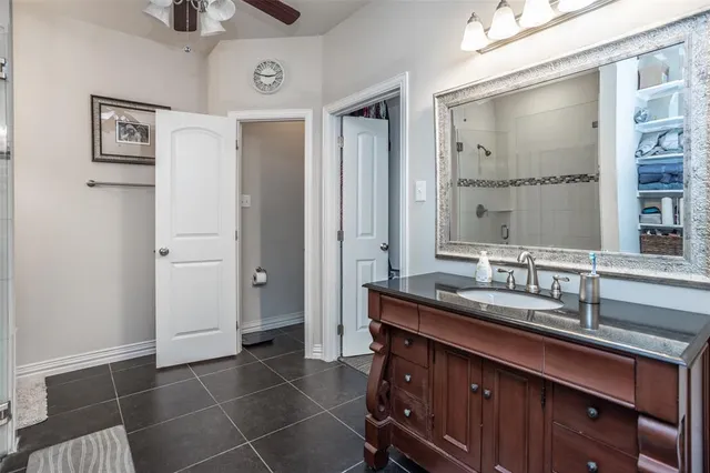 a bathroom with a granite countertop sink a mirror and a shower