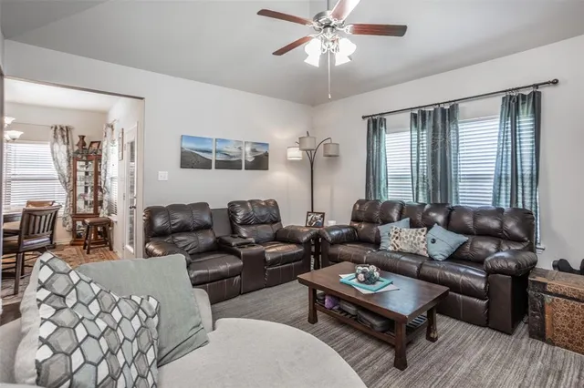 a living room with furniture a large window and a chandelier