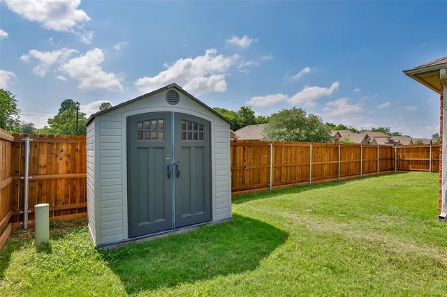 a view of a backyard with potted plants and wooden fence