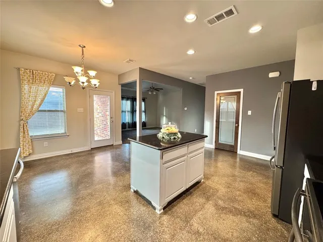 a kitchen with granite countertop a sink cabinets and stainless steel appliances
