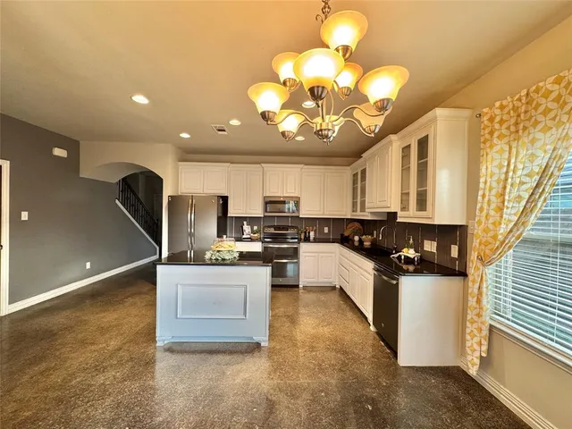 a kitchen with stainless steel appliances granite countertop a sink a stove and a refrigerator