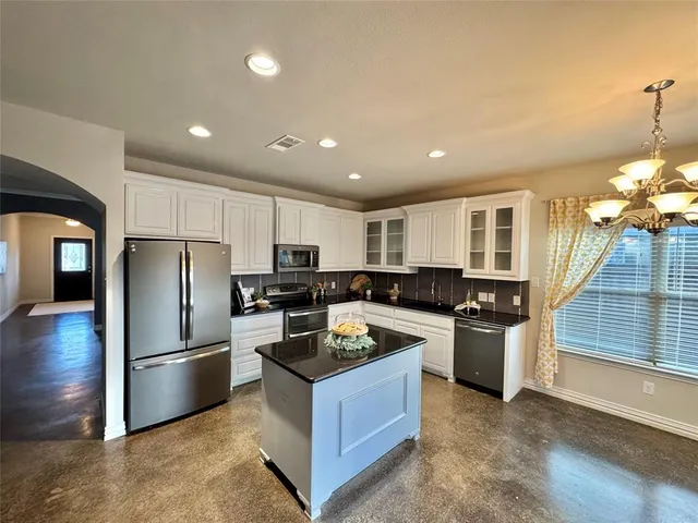 a kitchen with stainless steel appliances granite countertop a refrigerator a stove a sink and a refrigerator