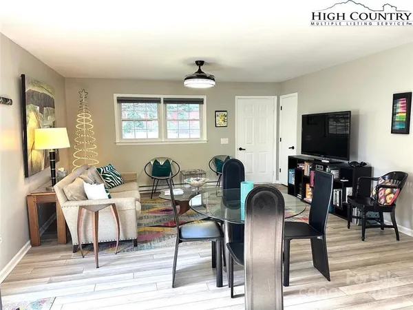 a living room with furniture a chandelier and a flat screen tv