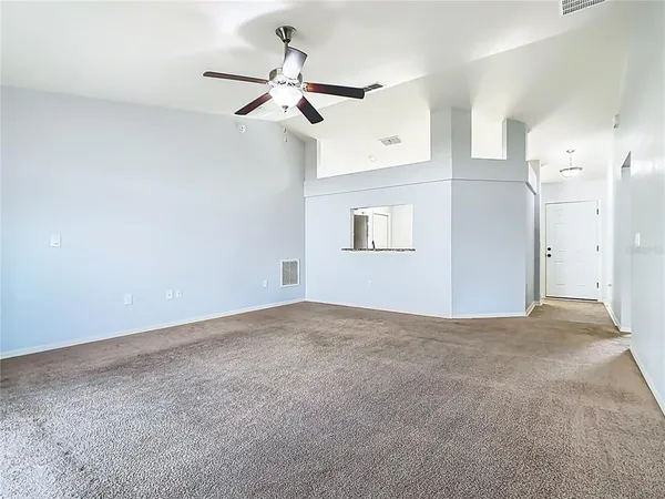 a view of a big room with a ceiling fan and a window