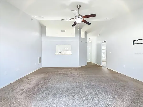 an empty room with a empty space and a ceiling fan