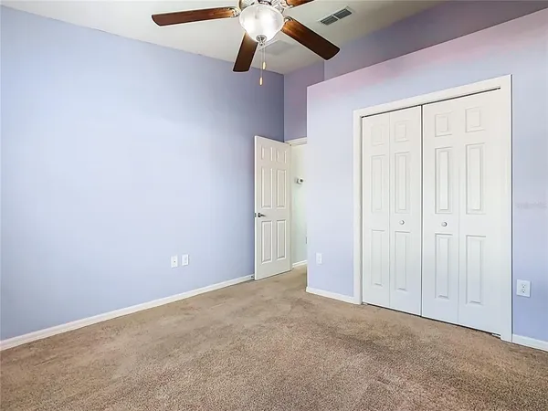 an empty room with a ceiling fan and a chandelier fan
