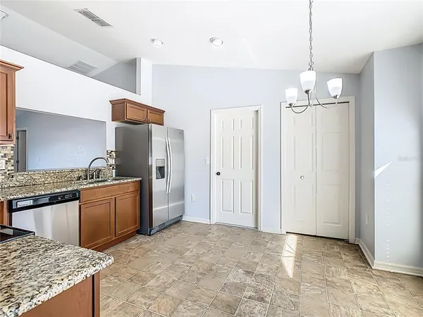 a kitchen with granite countertop a sink stove and refrigerator