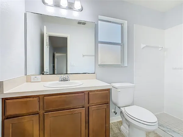 a bathroom with a sink toilet vanity and mirror