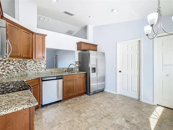 a kitchen with stainless steel appliances granite countertop a sink stove and refrigerator