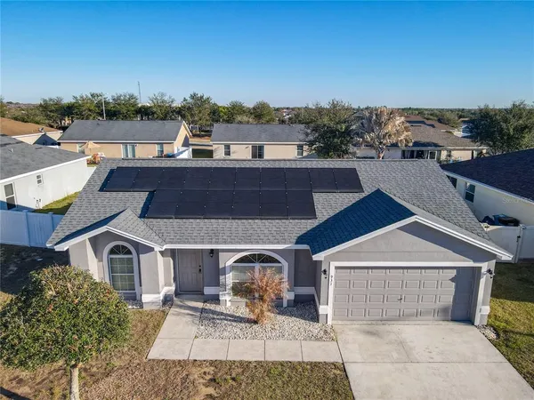 an aerial view of a house with couches and white kitchen