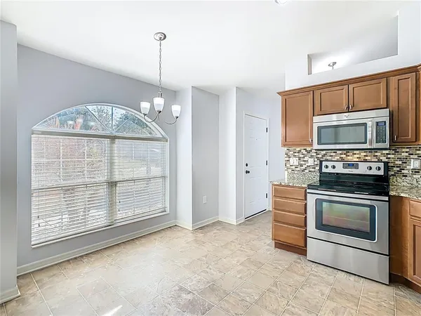 a view of an empty room with a fireplace and a window
