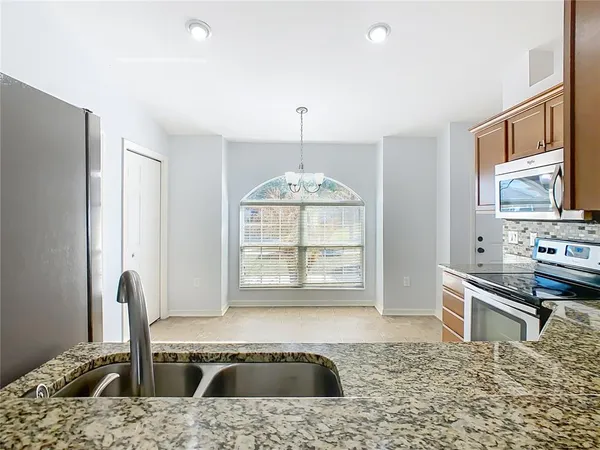 a kitchen with stainless steel appliances granite countertop a stove a sink and a microwave