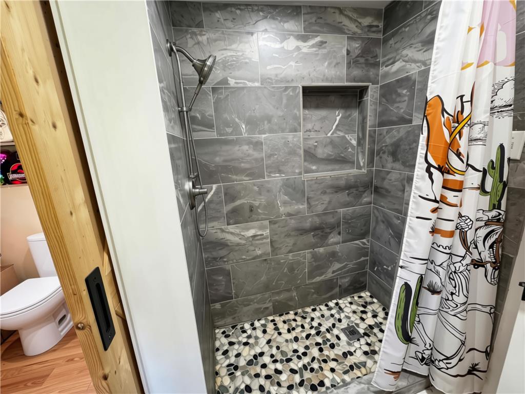 108 Effort Neola Road Effort, PA 18330 - Photo 18 of 31 Modern shower with sleek tiled walls and a unique pebble floor offers a refreshing cleanse.