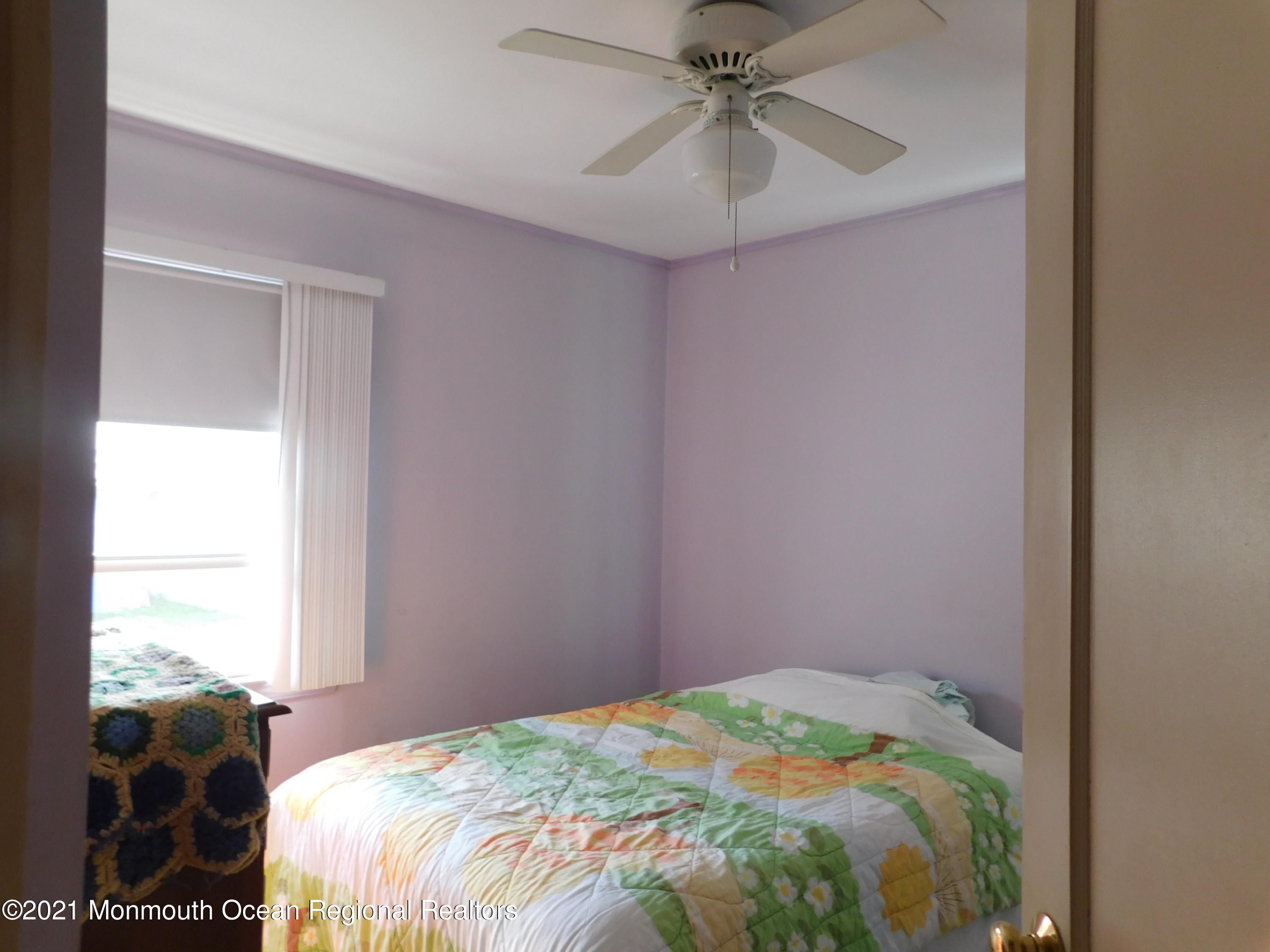 307 Eastham Road Point Pleasant, NJ 08742 - Photo 7 of 11 a bedroom with a bed and a chandelier
