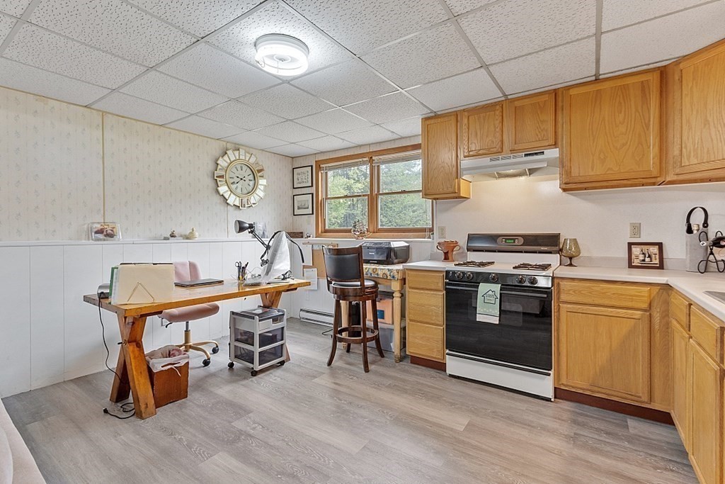 68 Gardner Road Winchendon, MA 01475 - Photo 23 of 41 a kitchen with stainless steel appliances a stove a sink dishwasher and a dining table with wooden floor