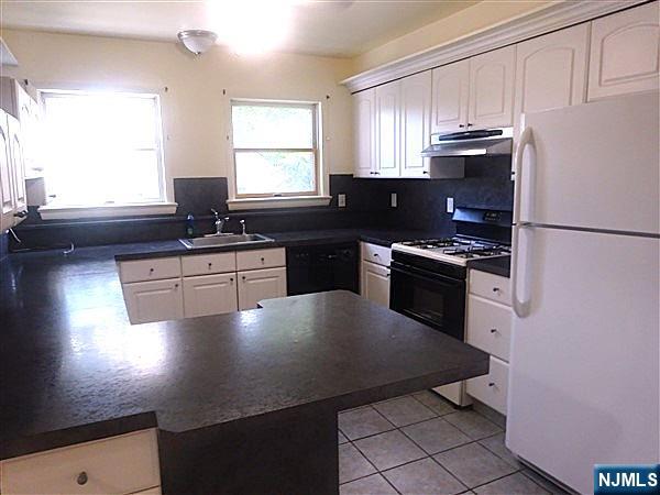 700 Kinderkamack Road River Edge, NJ 07661 - Photo 17 of 19 a kitchen with a sink a stove cabinets and a window