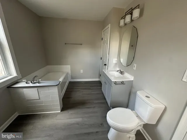 a bathroom with a tub toilet and window