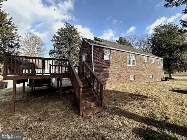 a view of backyard with deck and outdoor seating
