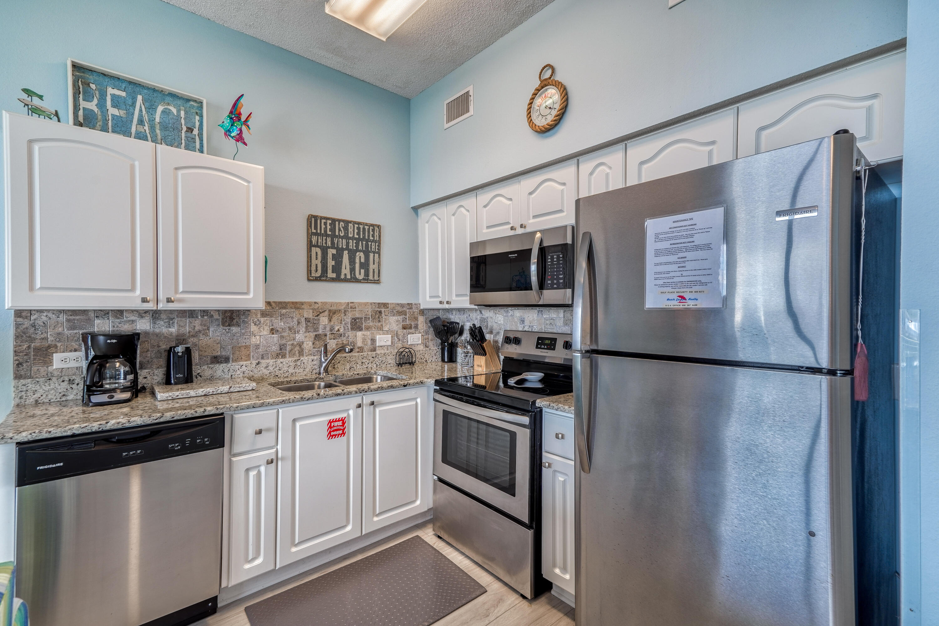 145 Spires Lane, Unit 406 Santa Rosa Beach, FL 32459 - Photo 5 of 38 a kitchen with stainless steel appliances white cabinets and a refrigerator