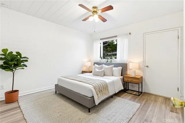 a bedroom with a bed chandelier and a window