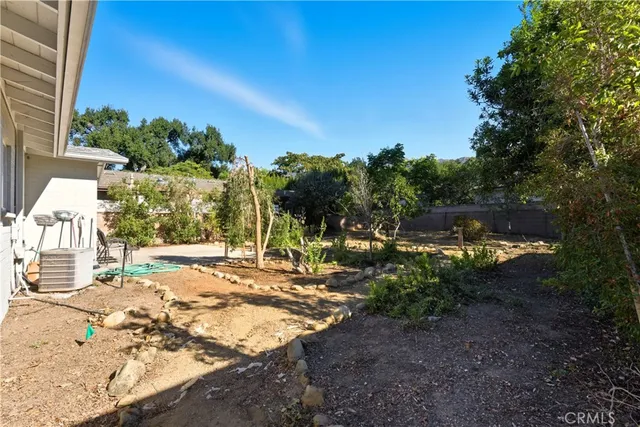 a view of a yard with plants and trees