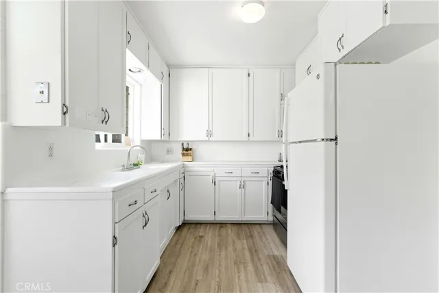 a kitchen with cabinets appliances a sink and a window