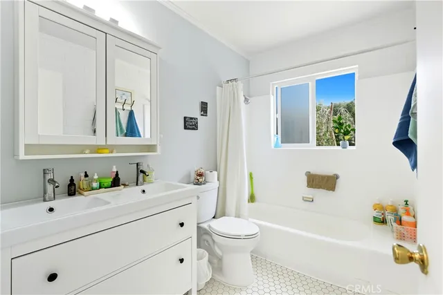 a bathroom with a sink a toilet a mirror a vanity a bath tub and shower