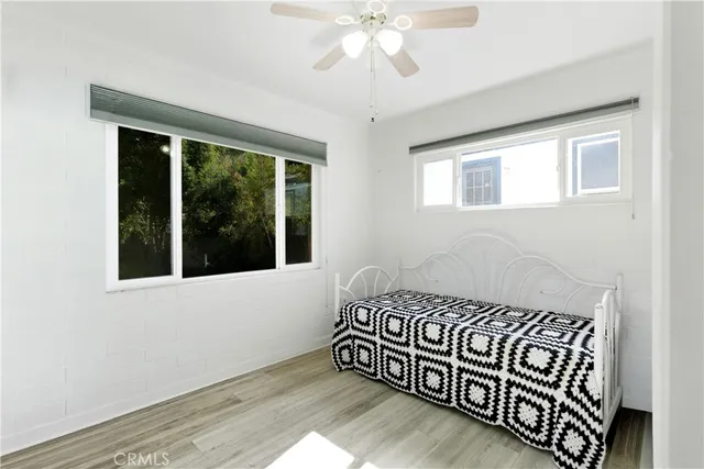 a view of a bedroom with wooden floor and windows