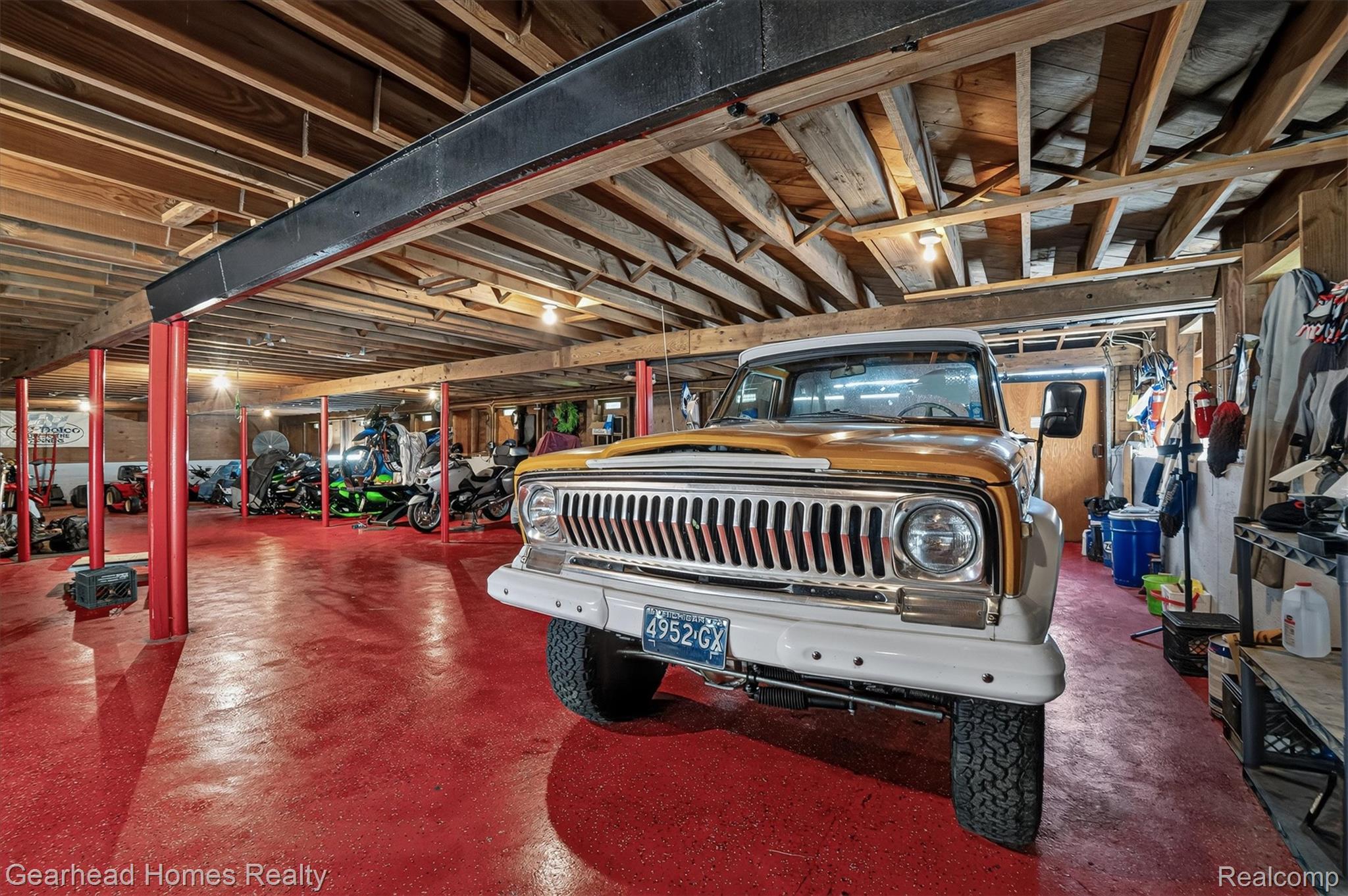 3486 West Drahner Road Oxford, MI 48371 - Photo 32 of 51 Spacious Basement featuring a durable red epoxy floor, exposed wood beam ceiling, multiple support pillars, and integrated overhead lighting