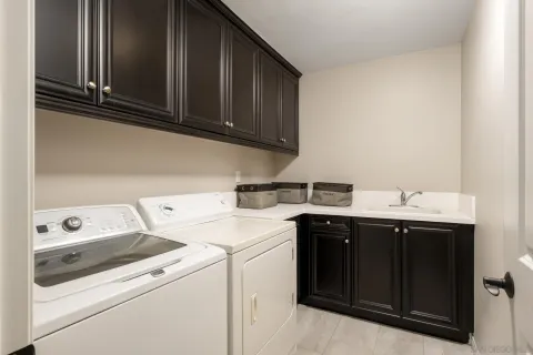 a utility room with sink dryer and washer