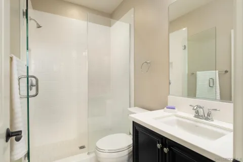 a bathroom with a granite countertop sink toilet a shower and a mirror