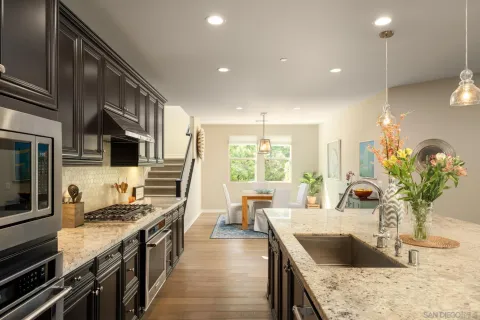 a kitchen with stainless steel appliances granite countertop a sink stove and refrigerator