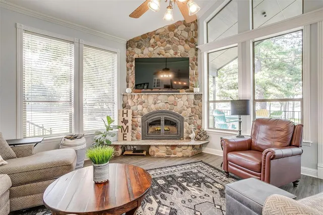 a living room with furniture a large window and a fireplace