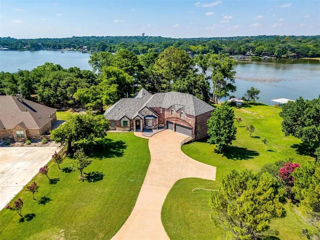 an aerial view of a house with a garden and lake view