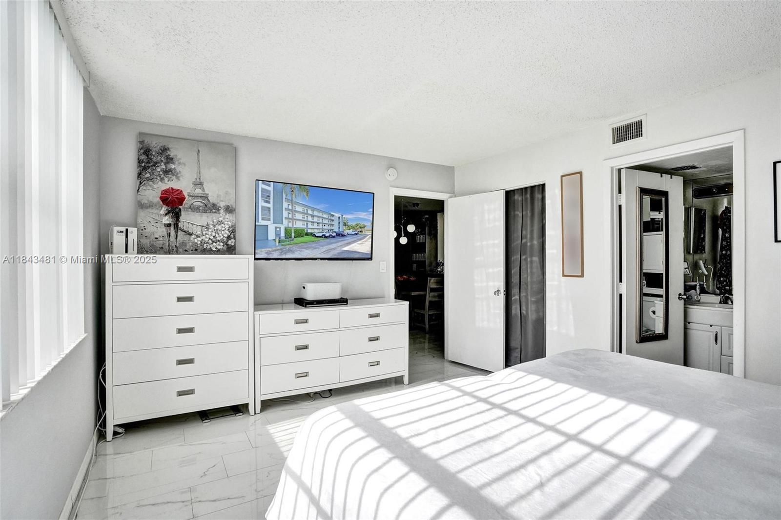 7664 Northwest 18th Street, Unit 405 Margate, FL 33063 - Photo 16 of 46 a bedroom with a bed and a dresser