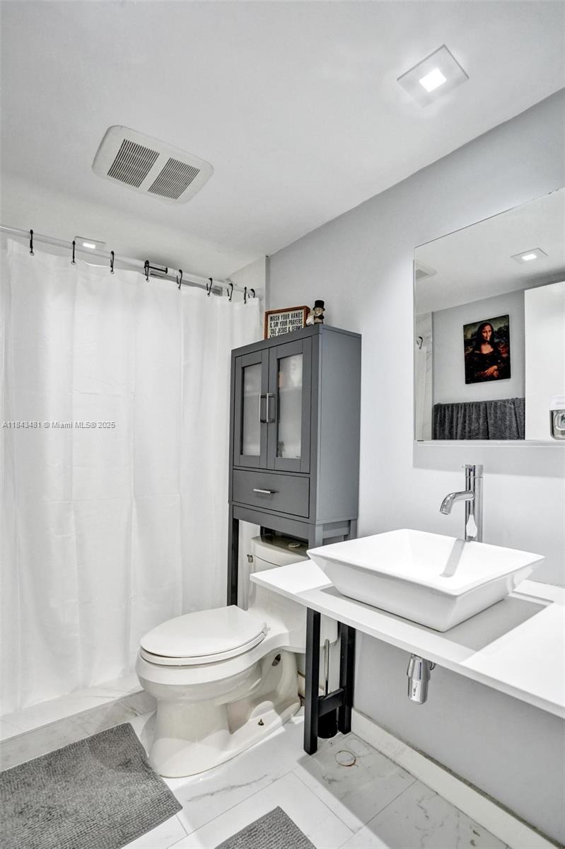 7664 Northwest 18th Street, Unit 405 Margate, FL 33063 - Photo 20 of 46 a bathroom with a sink toilet a mirror and shower