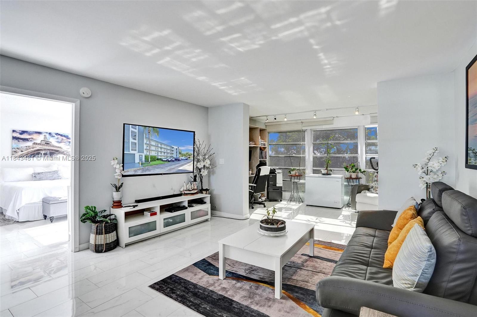 7664 Northwest 18th Street, Unit 405 Margate, FL 33063 - Photo 26 of 46 a living room with furniture and a flat screen tv