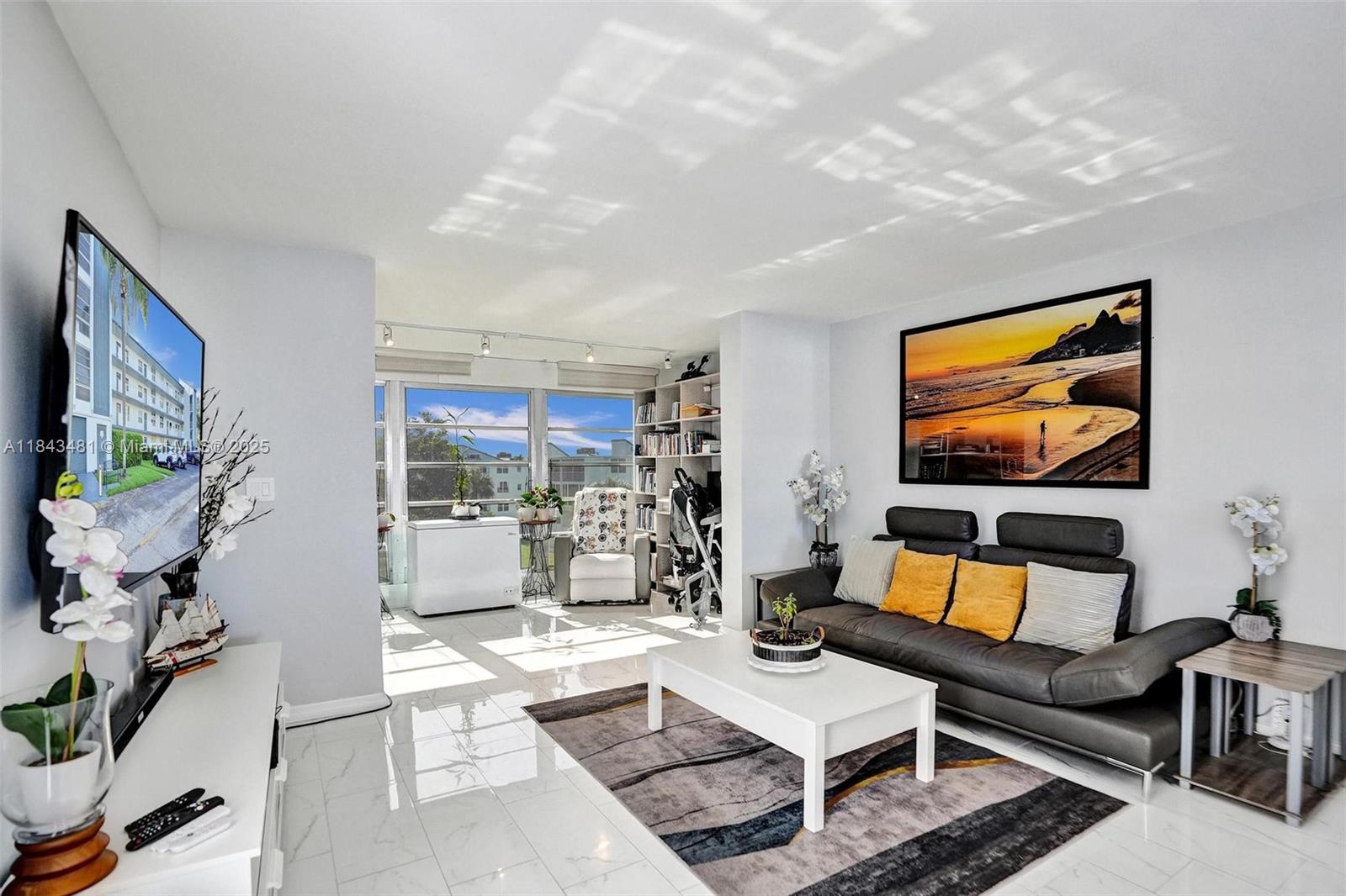 7664 Northwest 18th Street, Unit 405 Margate, FL 33063 - Photo 27 of 46 a living room with furniture a rug and a flat screen tv