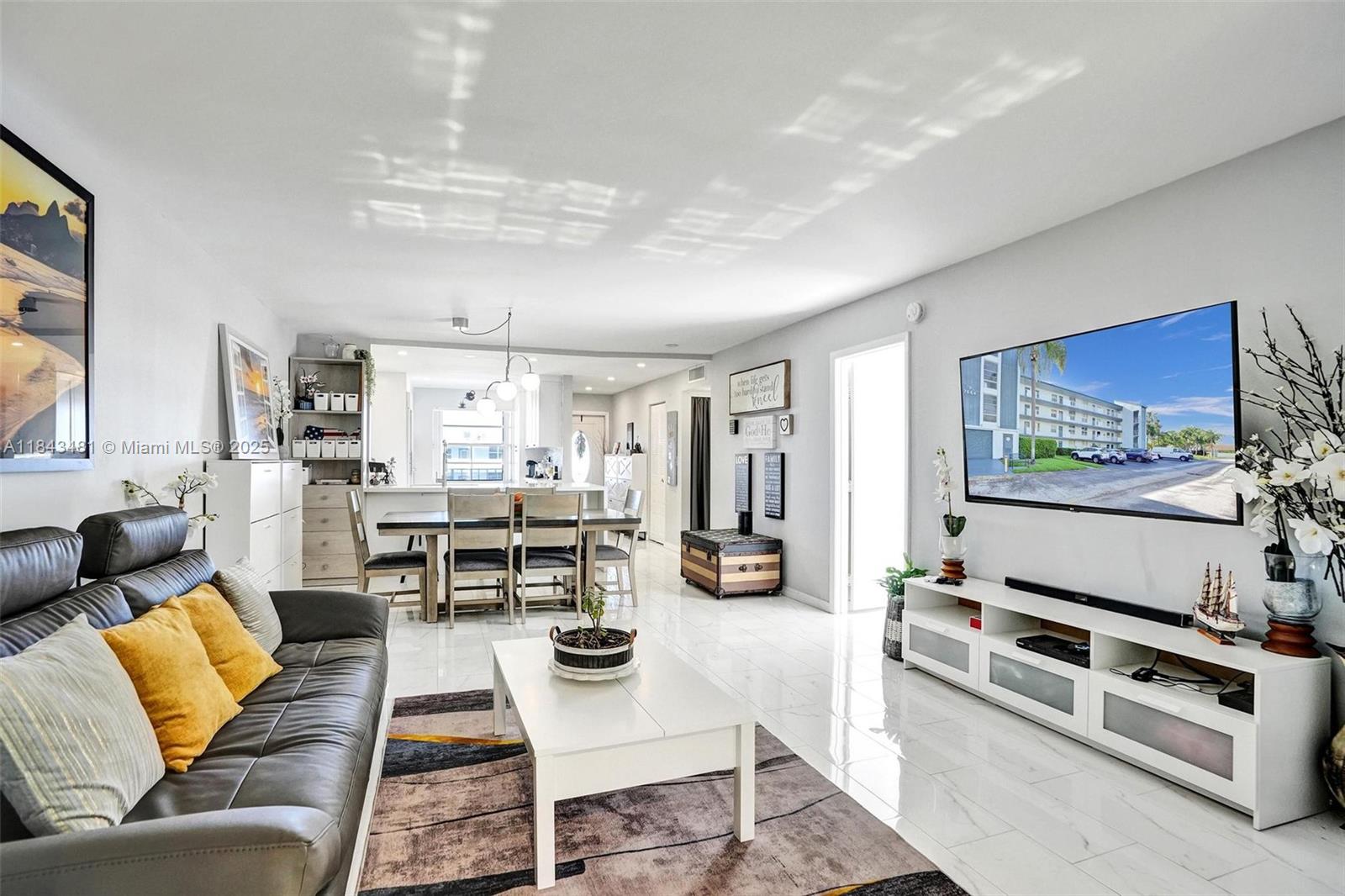 7664 Northwest 18th Street, Unit 405 Margate, FL 33063 - Photo 29 of 46 a living room with furniture and a flat screen tv