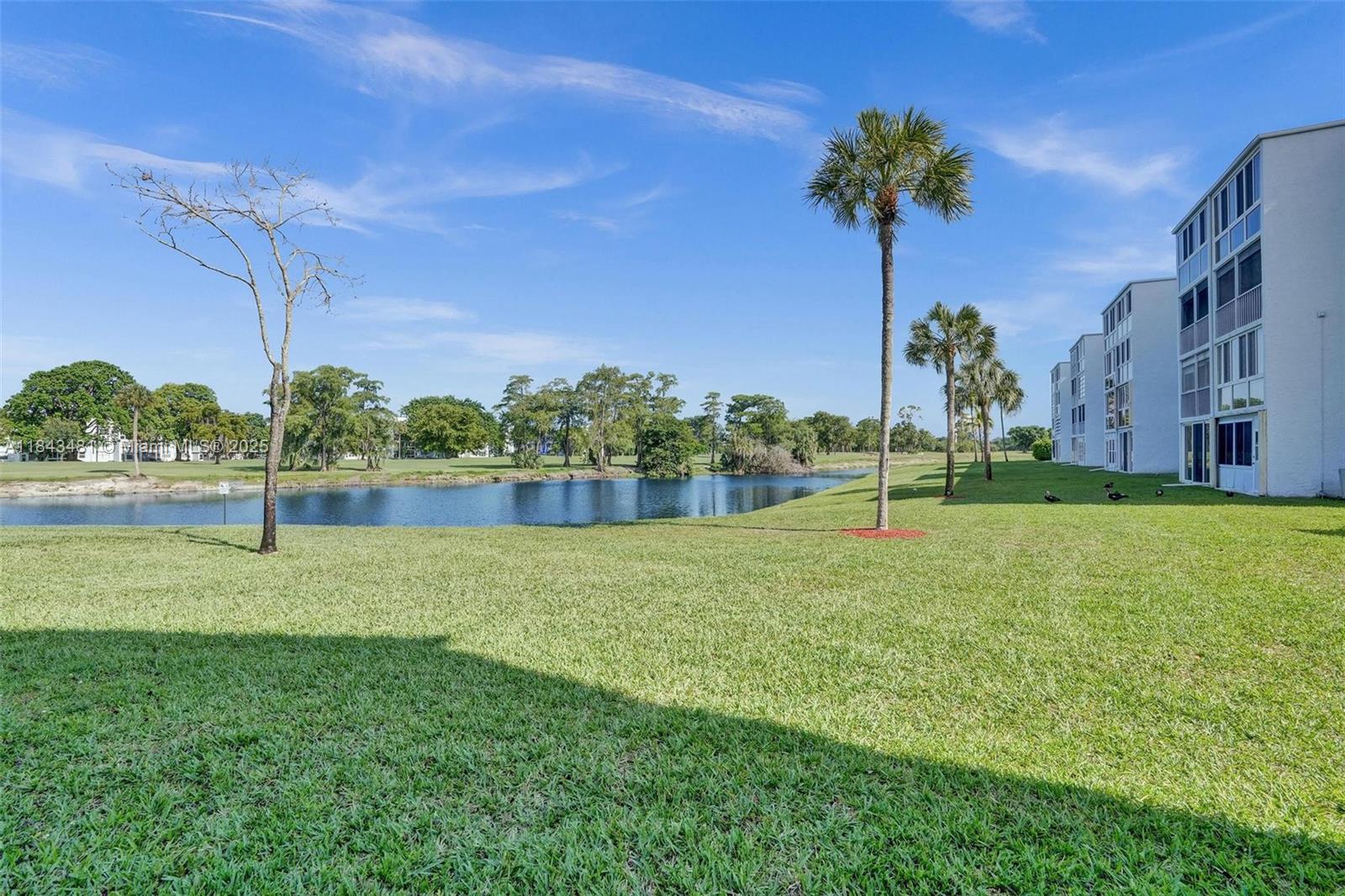 7664 Northwest 18th Street, Unit 405 Margate, FL 33063 - Photo 38 of 46 a view of a garden with a building in the background