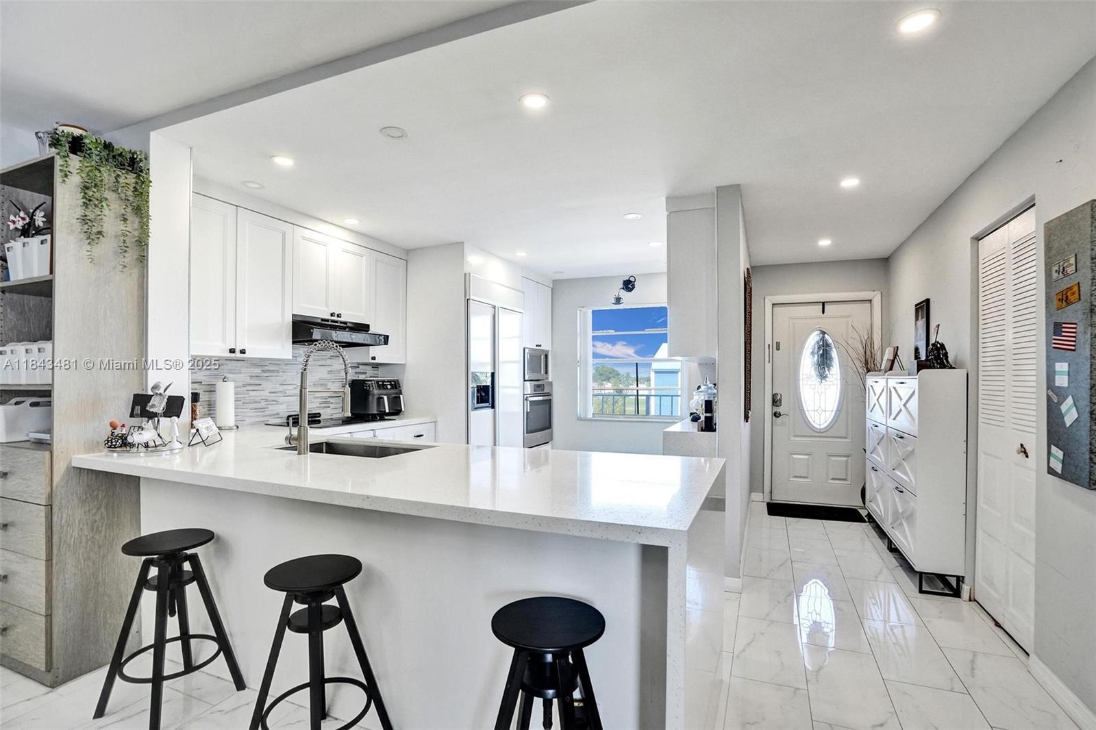 7664 Northwest 18th Street, Unit 405 Margate, FL 33063 - Photo 4 of 46 a kitchen with refrigerator and chairs