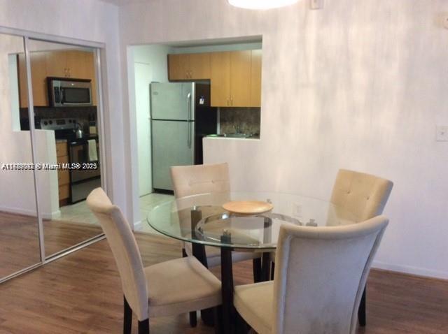 200 178th Drive, Unit 504 Sunny Isles Beach, FL 33160 - Photo 4 of 7 a dining room with furniture and window