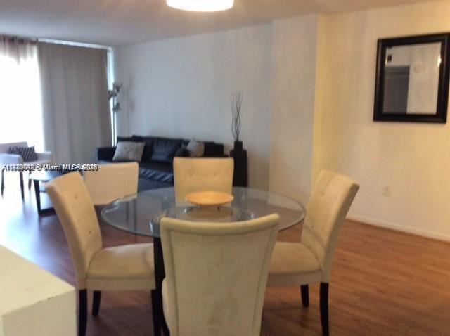 200 178th Drive, Unit 504 Sunny Isles Beach, FL 33160 - Photo 5 of 7 a dining room with furniture and wooden floor