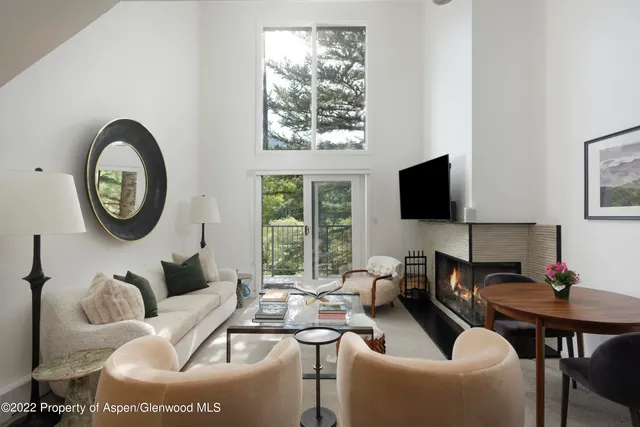a living room with furniture a flat screen tv and a window